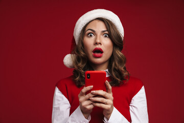 Shocked young woman in christmas santa hat