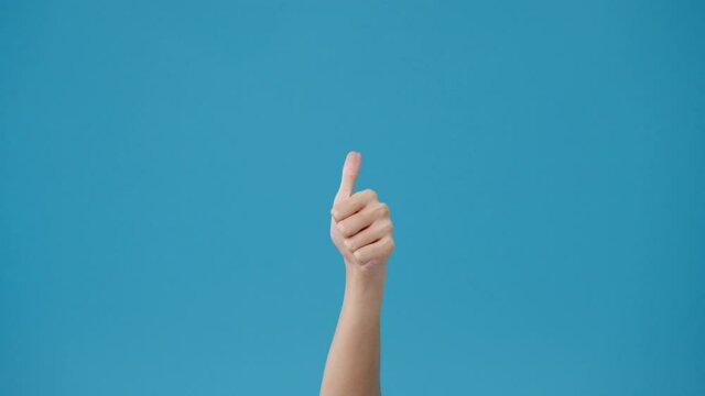 Young woman hand showing thumb up sign with fingers isolated over blue background in studio. Copy space for place a text, message for advertisement. Advertising area, mock up promotional content.