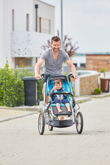Vater transportiert Kind in Kinderwagen Fahrrad