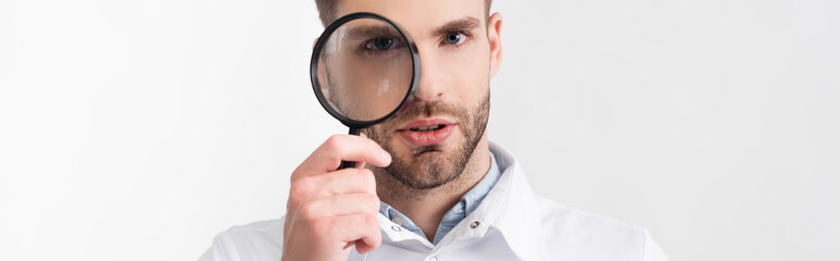 Portrait of bearded ophthalmologist looking through loupe isolated on white, banner