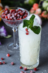 Summer fresh cold drinks. Ice lemonade with lemon decorated with cranberries and mint on an outdoor table. lemonade in a glass