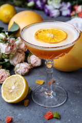 Orange cocktail with a slice of orange on a black concrete background. Summer cocktail concept with decor