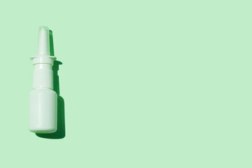 White medical nasal spray bottle on aqua mint background flat lay with harsh shadow minimalism style. Remedy against allergies runny nose, cold flu, viral diseases. COVID-19 pandemic, rhinitis therapy