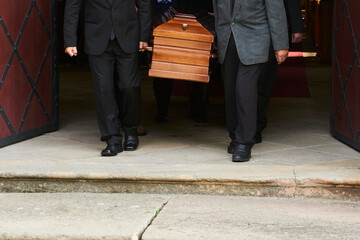 Group of survivors carries a coffin out of the church after a funeral mass