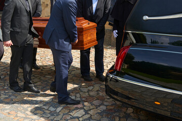 Group of survivors carries a coffin out of the church after a funeral mass - obrazy, fototapety, plakaty
