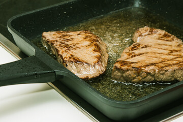 Beef steaks Sizzling in a pan of boiling oil.