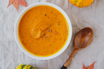 Hot pumpkin soup with mustard in a bowl on white background.