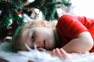 little cute boy playing with Christmas tree. New Year, Christmas, happy holidays, winter concept.