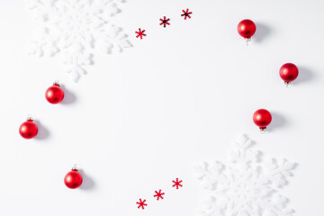 Christmas minimal holiday composition. Frame made of snowflakes and red decorations on white background. Christmas, New Year, winter concept. Flat lay, top view, copy space