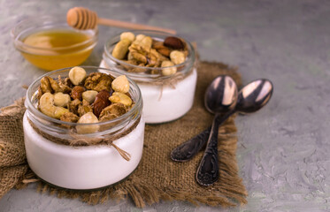 
Greek yogurt with honey and nuts on a gray background.
Close-up.
