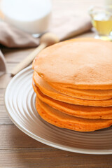 Tasty pumpkin pancakes on table, closeup