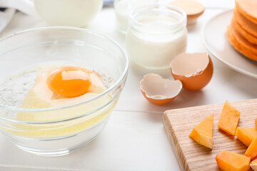 Ingredients for preparing tasty pumpkin pancakes on table