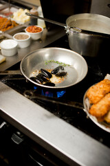 Steamed mussels. Mussels being prepared by a chef in a restaurant kitchen. Classic Italian restaurant entree favorite. Shellfish and seafood prepared with pork, sauces, meats and cheeses.