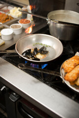 Steamed mussels. Mussels being prepared by a chef in a restaurant kitchen. Classic Italian restaurant entree favorite. Shellfish and seafood prepared with pork, sauces, meats and cheeses.