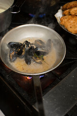 Steamed mussels. Mussels being prepared by a chef in a restaurant kitchen. Classic Italian restaurant entree favorite. Shellfish and seafood prepared with pork, sauces, meats and cheeses.