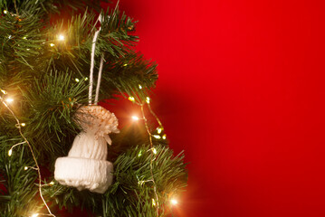 Christmas tree decorated with garland and handmade winter hat toy