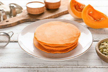 Tasty pumpkin pancakes on table