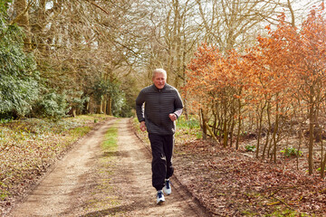 Smiling Senior Man Running In Autumn Countryside Exercising During Covid 19 Lockdown