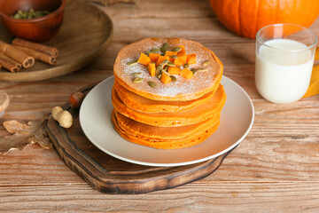 Tasty pumpkin pancakes on table