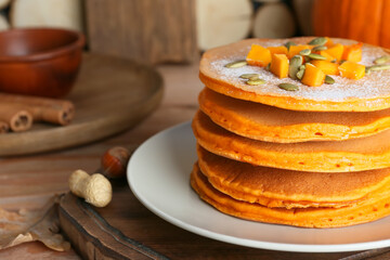 Tasty pumpkin pancakes on table, closeup