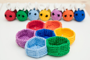 Fototapeta na wymiar Colorful beehive with bees. Crochet safe toys for babies. Processed egg craft ideas are a bright Easter-colored rainbow-colored educational toy. Preschool game for young children. Montessori education