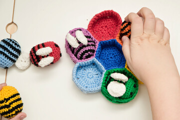 Colorful beehive with bees. Crochet safe toys for babies. Processed egg craft ideas are a bright Easter-colored rainbow-colored educational toy. Preschool game for young children. Montessori education