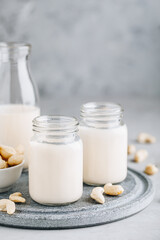 Cashew Nut Milk in glass on gray stone background