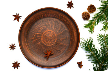 clay plate with christmas decor and anise top view isolated on a white background