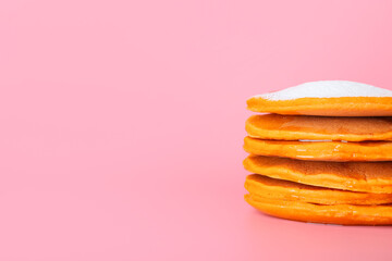 Tasty pumpkin pancakes on color background