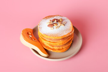 Tasty pumpkin pancakes on color background