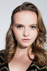 Fototapeta premium close up of serious young woman looking at camera isolated on grey