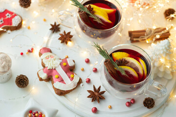 Christmas mulled red wine with spices and citrus on white wooden table. Traditional hot drink at Christmas