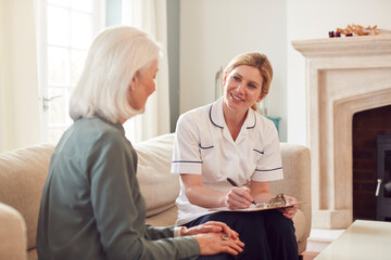 Obraz premium Female Doctor Making Home Visit To Senior Woman For Medical Check