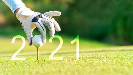 Golfer woman putting golf ball for Happy New Year 2021 on the green golf for new healthy.  copy...