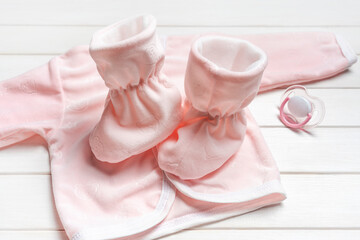 Cute pink stuff. Baby clothes: socks, shirt and baby pacifier. Accessories for newborn