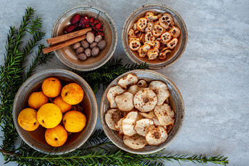 Ceramic bowls with variety of fruits and spices. Flat lay view of winter home cooking decoration.
