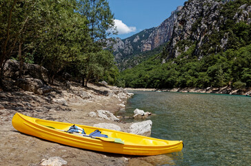 Fototapeta na wymiar Yellow kayak on shore of Verdon river canyon. The Verdon Gorge in Provence, France, Europe.