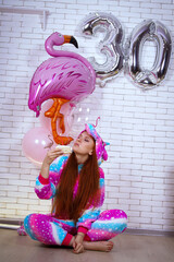 birthday girl in rainbow pajamas with balloons and cake 30 years old
