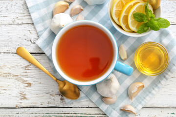 Cup of healthy garlic tea on table