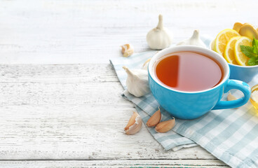 Cup of healthy garlic tea on table