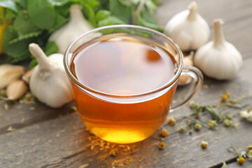 Cup of healthy garlic tea on table