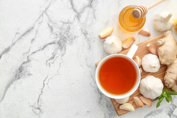 Cup of healthy garlic tea on white background