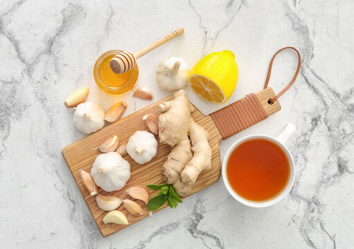 Cup of healthy garlic tea on white background