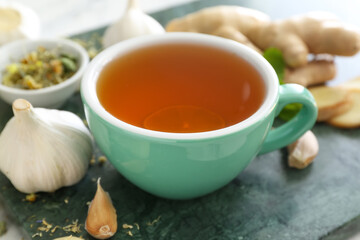 Cup of healthy garlic tea on table