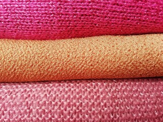 
background of a stack of knitted pink and orange sweaters
