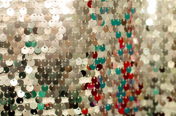 Silver patterned texture. Elegant fabric in  art Deco style with round silver sequins with multi-colored speckles. Fancy sparks.