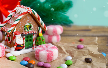 Christmas composition with gingerbread house and peppermint candies over holiday background. Home decor.