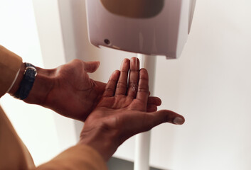 Close Up Of Businessman Using Hand Sanitiser In Modern Office During Health Pandemic