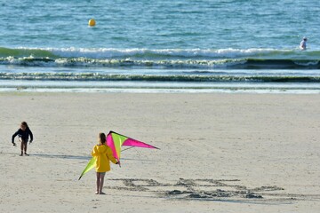children playing kite on a beach in brittany. France 