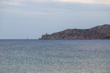 View of the lighthouse on the peninsula, Paralia Gialos, Ios Island, Greece.